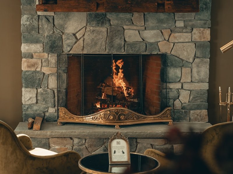 Stone-faced fireplace with wood mantel and burning logs — the kind of finished install Fireplace Ottawa delivers