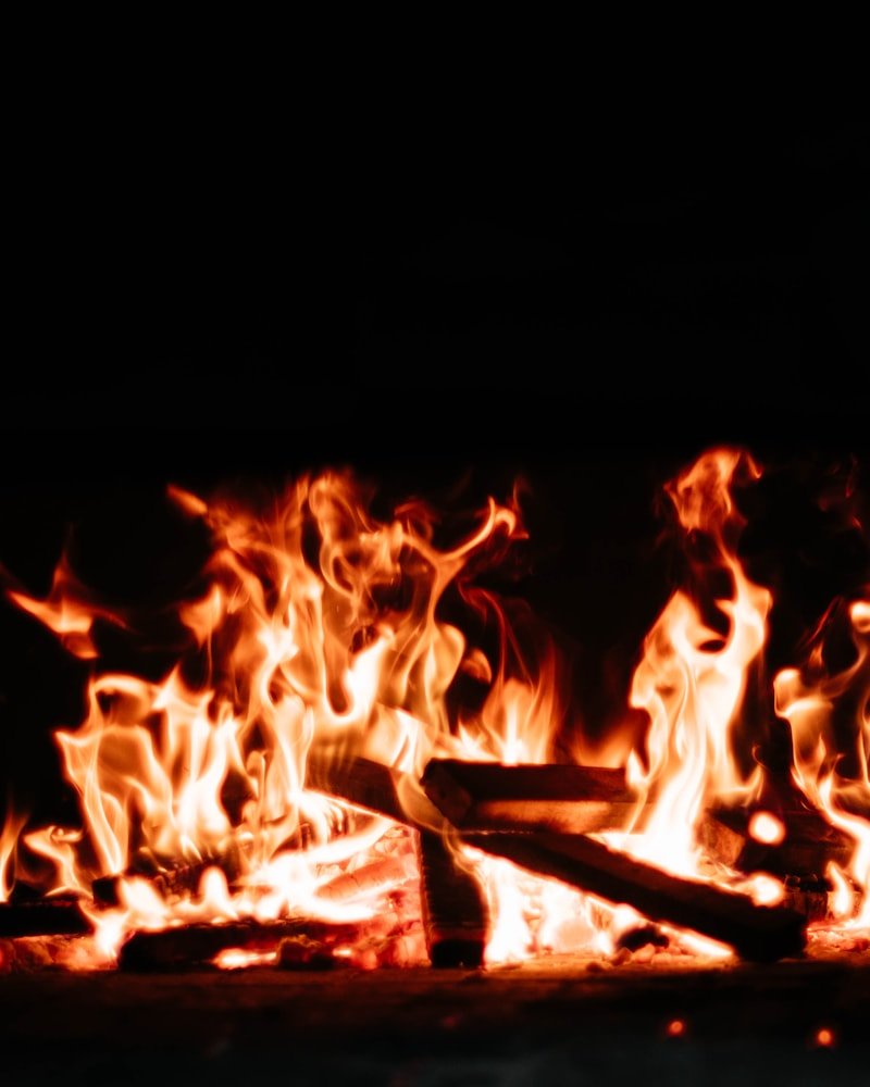 Dramatic close-up of wood logs burning in an Ottawa fireplace with vivid amber flames